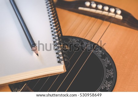 Music concept, Notebook and pencil on guitar for writing music