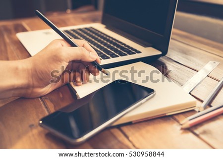 Closeup of businessman typing on a keyboard on the brown wooden desk.Vintage retro picture style