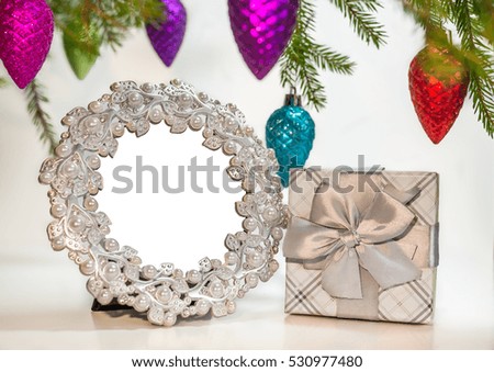 Empty photo frame with present under decorated pine tree branches - Christmas tree