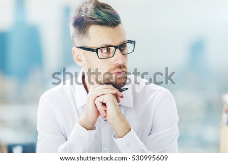Close up portrait of handsome european man in spectacles on blurry city background