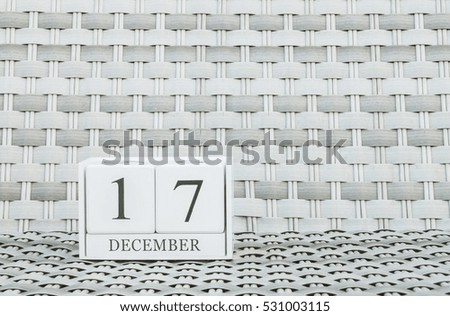 Closeup surface white wooden calendar with black 17 december word on blurred weave wood chair textured background with copy space , selective focus at the calendar