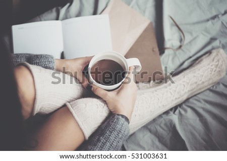 Woman holding cup of coffee in hands. Top view point, soft focus. winter and people concept. vintage toned picture with filter