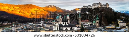 Salzburg landmarks in Austria. Aerial view of Salzburg, Austria at sunset. Castle and Cathedral with mountain at the background.
