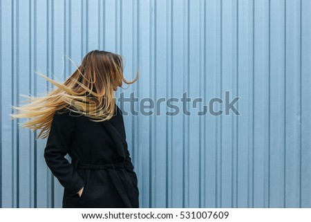 Young beautiful woman with blond straight long hairs in motion