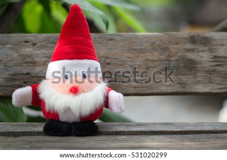 Santa Claus doll on a wooden chair.