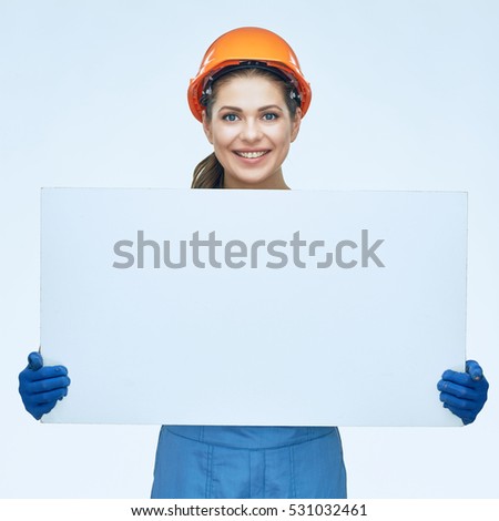 Builder holding white banner with copy space. Smiling woman coverall wearing isolated portrait.