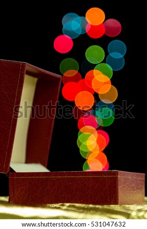Red gift box on dark background with colour bokeh