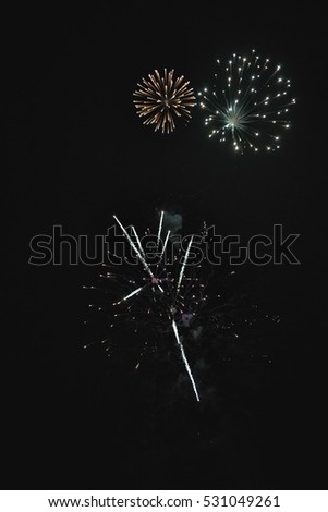 Shiny natural fireworks on dark sky background with little smoke