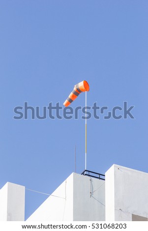 windsock on clear blue sky background in windy weather