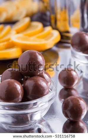 Chocolate candies in a small glass bowl close-up with blur and shallow depth of focus