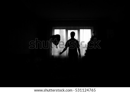 man near the window with a balloon in the hands of. Black and white