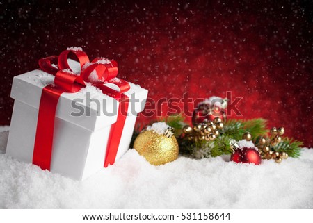Christmas gift and baubles on red bokeh background. Studio shot