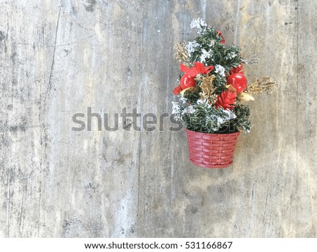Small christmas tree decoration hanging on the wooden wall.