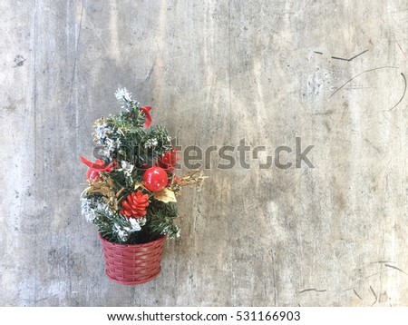 Small christmas tree decoration hanging on the wooden wall.