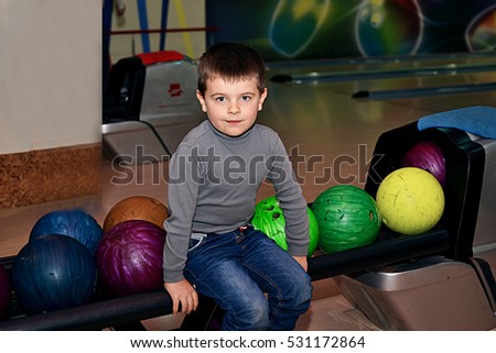 a child plays bowling a smile sits