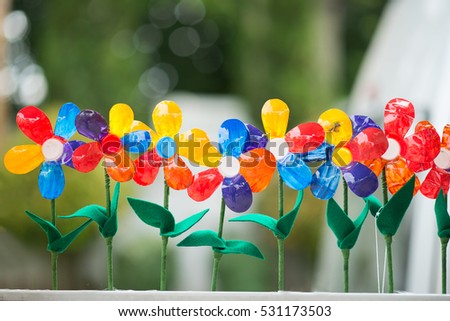 Recycled colorful plastic flowers in pot.Recycle decoration. Royalty-Free Stock Photo #531173503