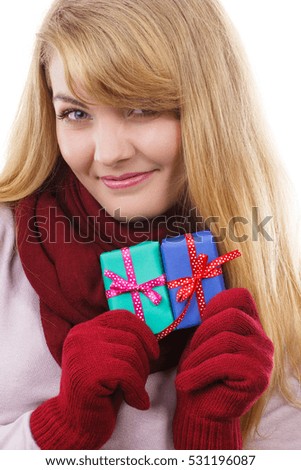 Smiling woman in woolen gloves holding wrapped gifts for Christmas, Valentine, birthday or other celebration, white background