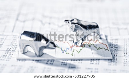 Bull and Bear are on a graphic with market prices. Royalty-Free Stock Photo #531227905