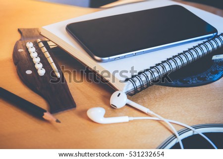 Concept of music, Smartphone, Notebook, Pencil and Earphone on guitar for writing music,Vintage retro picture style