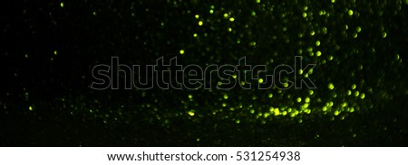 glitter vintage lights background. green and black. defocused.