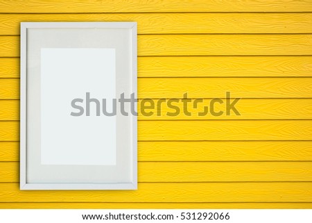 White empty frame on the wall wooden yellow.