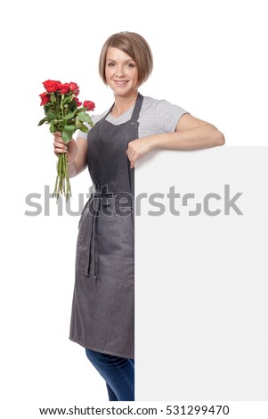 attractive woman florist with bunches of rose flowers standing next to the banner with empty copy space for text isolated on white background. floristry and business concept. advertisement blank board