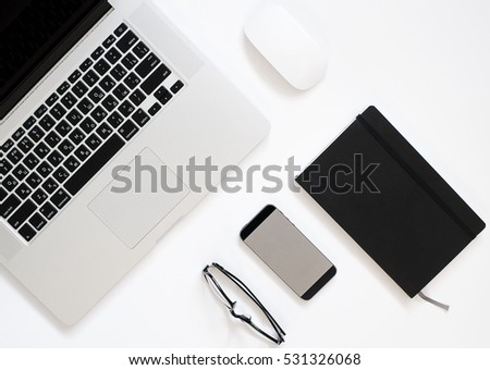 Office workplace with laptop, smart phone, notebook on the white table, flat lay concept photo