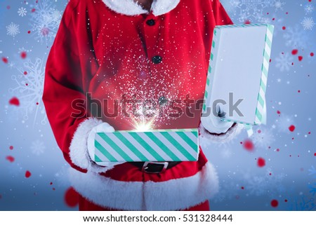 Midsection of Santa Claus opening gift box against snowflake pattern