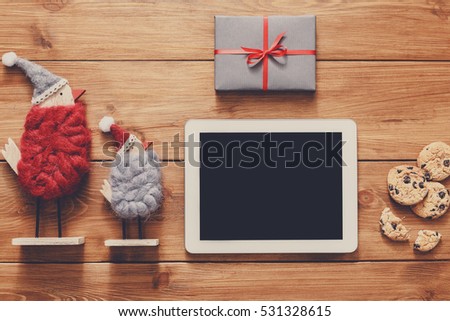 Christmas online shopping background. Tablet screen with copy space top view on wood, credit card, xmas toys and presents. Electronic devices, internet commerce on winter holidays concept