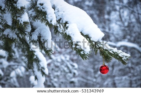 Decorated Christmas tree with red balloon in the forest