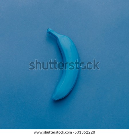 Blue banana on blue pastel background. Minimal style. Food concept. Flat lay.