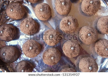 Background with chocolate balls.Truffles delicious dessert on silver paper.