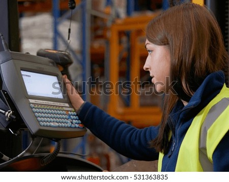 Worker operating forklift in warehouse