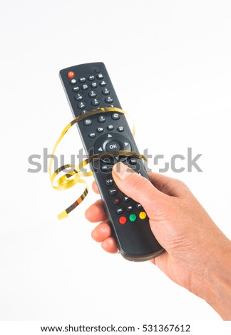 hand holding a remote control in a festive gold ribbon on white background
