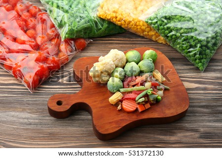 Frozen vegetables on wooden board