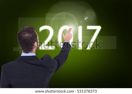Businessman in suit pointing these fingers against green background with vignette
