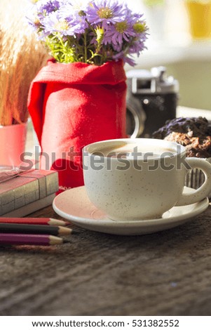 sunny morning breakfast table with a cup of coffee, bouquet of blue flowers muffins and old camera. place for lovely messages. soft focus image