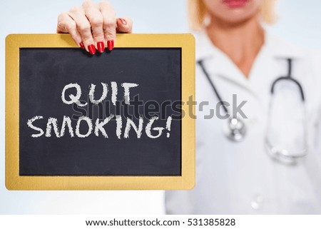 Quit Smoking Chalkboard Sign Held By Female Doctor.