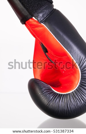 Red and black boxing gloves on a glass table isolated on white background