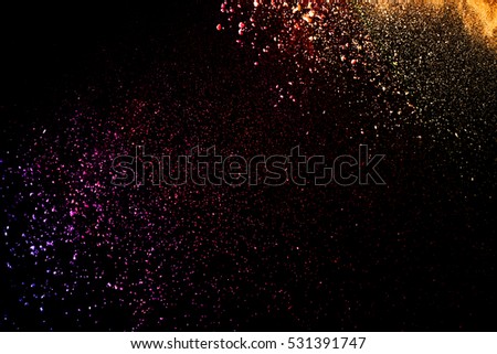 Freeze motion of color powder coming down on black background,Abstract design of falling dust cloud, snow fall concept.