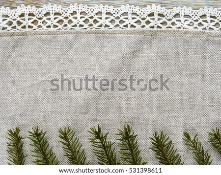 Detail view of cloth with fir tree branch over wooden texture close-up. Christmas border with decor, ornament on an old table background.