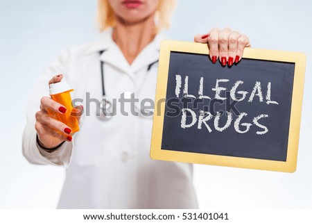 Illegal Drugs Chalkboard Sign Held By Female Doctor Holding Prescription Bottle.