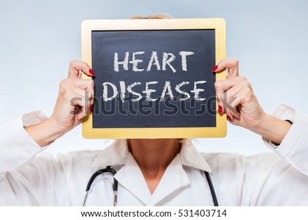Heart Disease Chalkboard Sign Held By Female Doctor In Front Of Face.