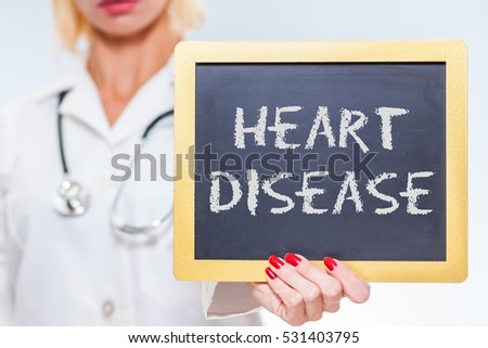 Heart Disease Chalkboard Sign Held By Female Doctor.