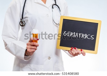 Geriatrics Chalkboard Sign Held By Female Doctor Holding Prescription Bottle.
