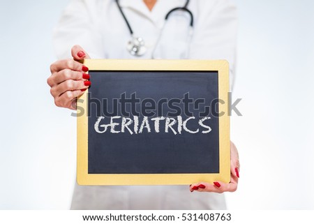 Geriatrics Chalkboard Sign Held By Female Doctor.