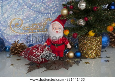 toy Santa Claus with bag of gifts at the Christmas tree on the background of the picture blizzard