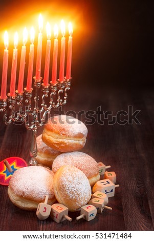 Symbols of jewish holiday hanukkah - menorah, donuts sufganiyot and dreidels. Copyspace background.
