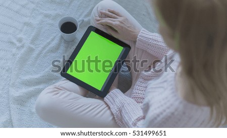 Woman at home relaxing reading on the tablet computer