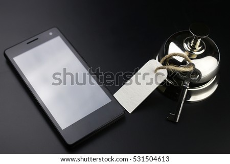 silver bell and the key at the reception in the hotel on a black background